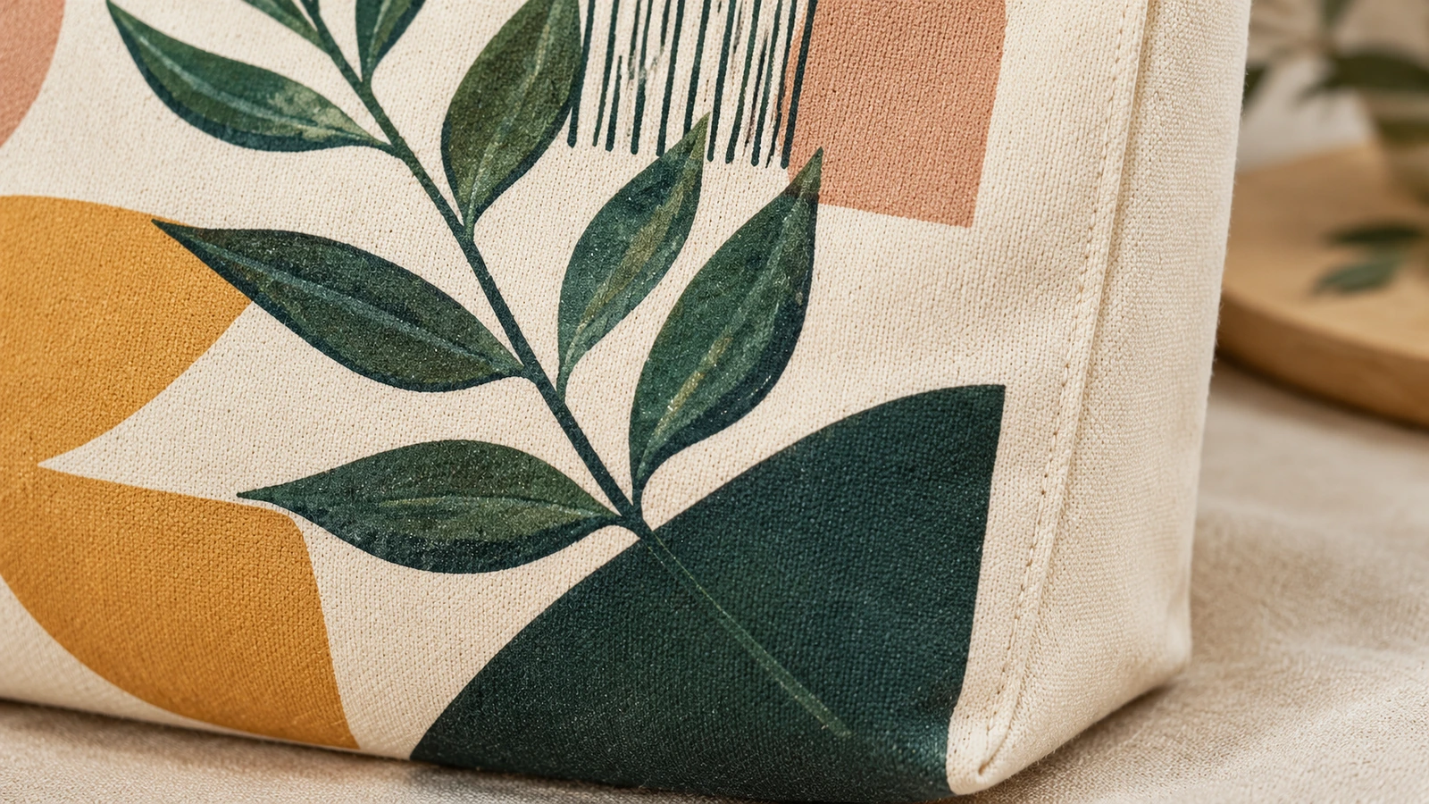 Ảnh cận cảnh túi tote canvas in, thể hiện họa tiết lá và nếp gấp hông được may